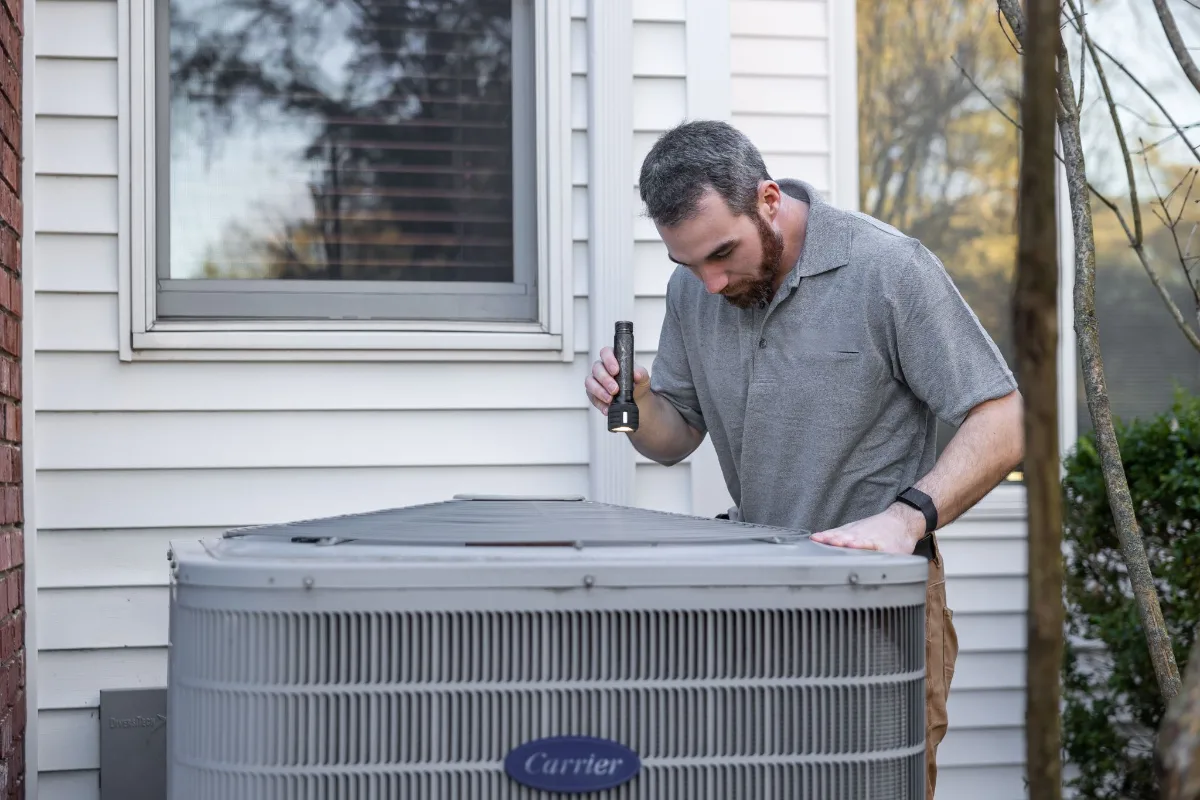 Home inspector checking an outdoor AC unit during a Texas home inspection